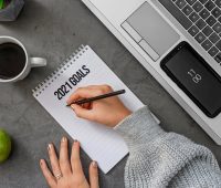 crop unrecognizable woman writing goals for upcoming year in notepad