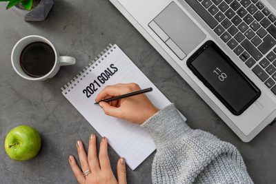 crop unrecognizable woman writing goals for upcoming year in notepad