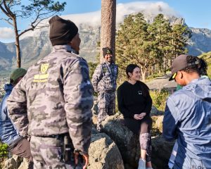 Female jogger chatting with Cobras Protection Team under trees on Table Mountain